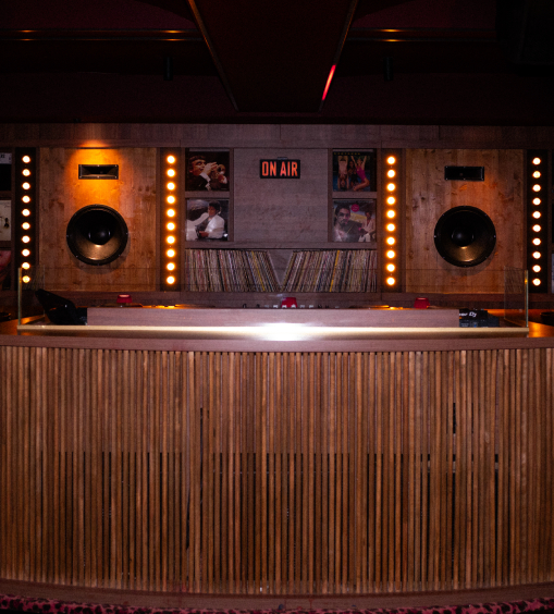 Cabine DJ du Cat Club avec platines, enceintes, collection de vinyles et panneau ON AIR illuminé – club courchevel