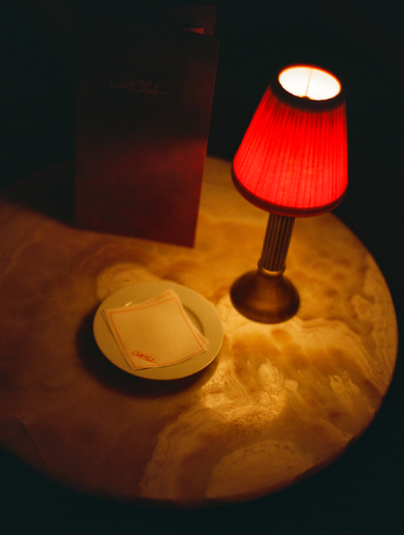 Table ronde en marbre avec lampe rouge, carte Cat Club et sous-verre &ndash; Cat Club Courchevel