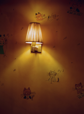 Applique murale dor&eacute;e allum&eacute;e entour&eacute;e d'illustrations de chats musiciens sur mur ocre &ndash; Cat Club Courchevel
