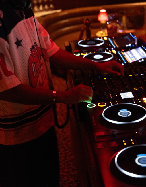 Salle du Cat Club côté banquettes, tableaux lumineux, seaux à champagne et lampes rouges sur tables rondes – club courchevel